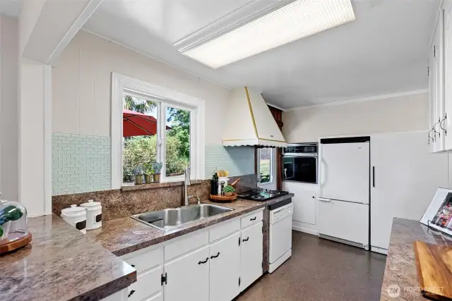 Kitchen view and easy door out to serving on the back deck and to upper garden area.