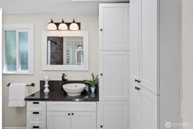 An updated Primary bath off the Kitchen is clean and light.