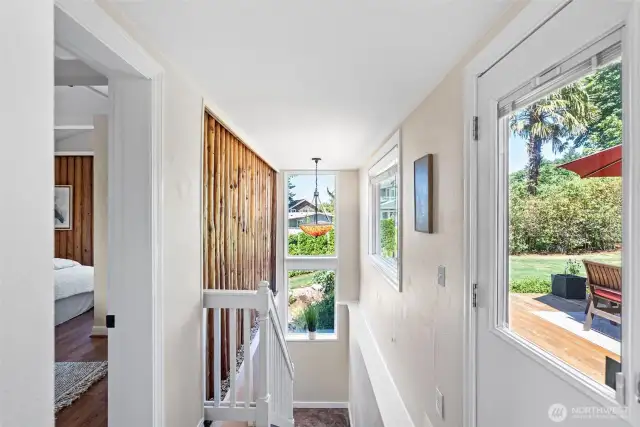 Internal stairs lead down to the main entry. There are so many possibilities for coming and going. Enter from the top level or from below. Currently the main entry is below, but the side door here could easily take one down to the parking allowing the lower level to be closed off.