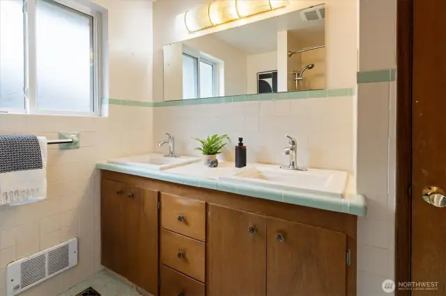 The main floor bathroom is retro-chic with dual sinks and vintage tile.