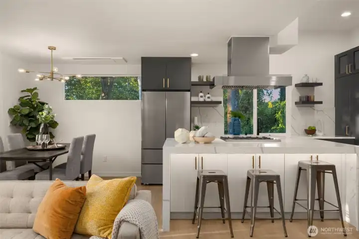 The kitchen is a true showpiece—sleek waterfall island, quartz countertops that shimmer in the light, designer pendant fixtures, and a seamless flow that invites conversation while you cook and host.