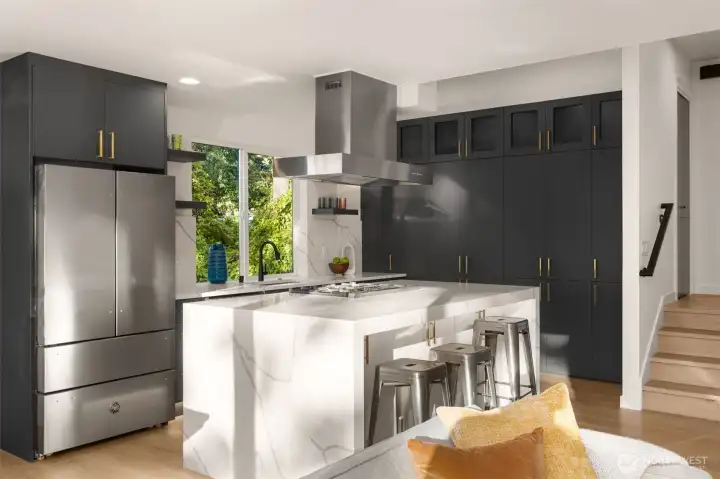 A chef’s dream, the kitchen boasts a professional-grade gas range, full-height tile backsplash, and perfectly placed windows that fill the space with morning light.