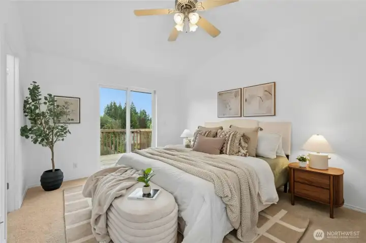 Primary bedroom with vaulted ceilings & spacious deck.