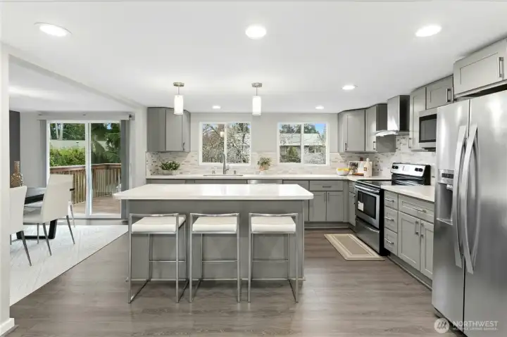 Updated kitchen with quartz countertops, stainless steel appliances and open-concept layout.