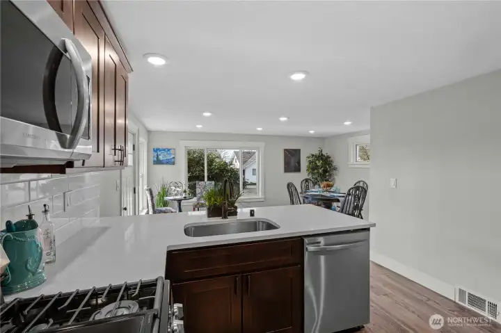 Gas Range and Overhead Microwave plus single basin stainless steel sink.