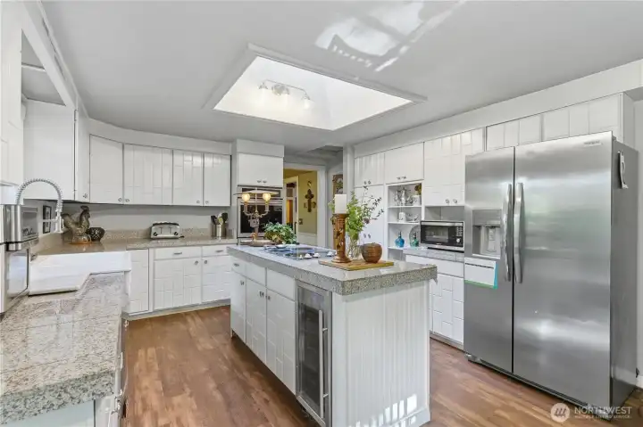 Granite tile counters and stainless steel appliances plus a beverage refrigerator with easy access.