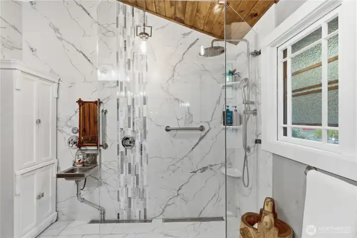 Spacious ADA-compliant primary bathroom designed for comfort and accessibility.  Barrier-free featuring roll-in shower and wide clearances.