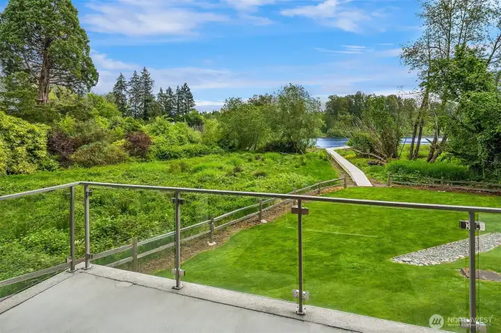 Enjoy the privacy of the natural landscaping from your elevated patio with glass panels