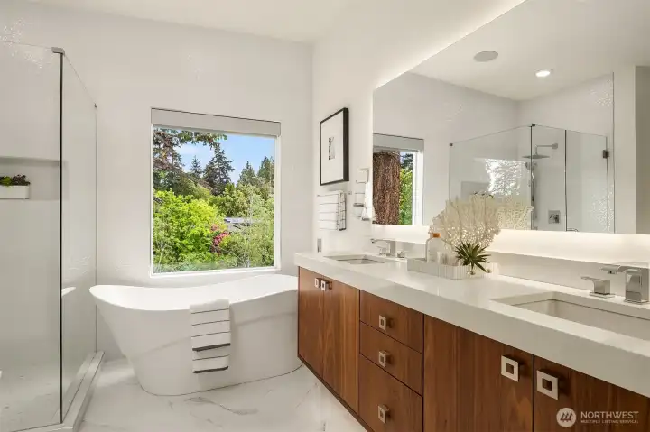 The primary bathroom includes lighted mirror, double vanity, free-standing glass enclosed shower, soaking tub, and private toilet
