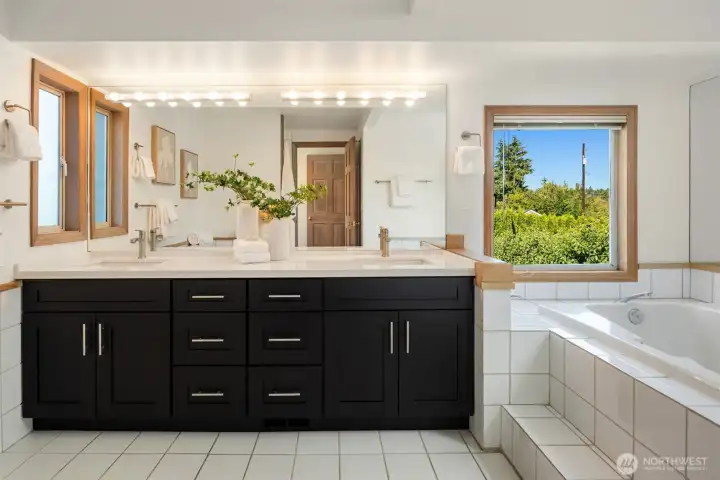 This spacious en suite features an oversized soaking tub, separate tiled shower and dual vanities.