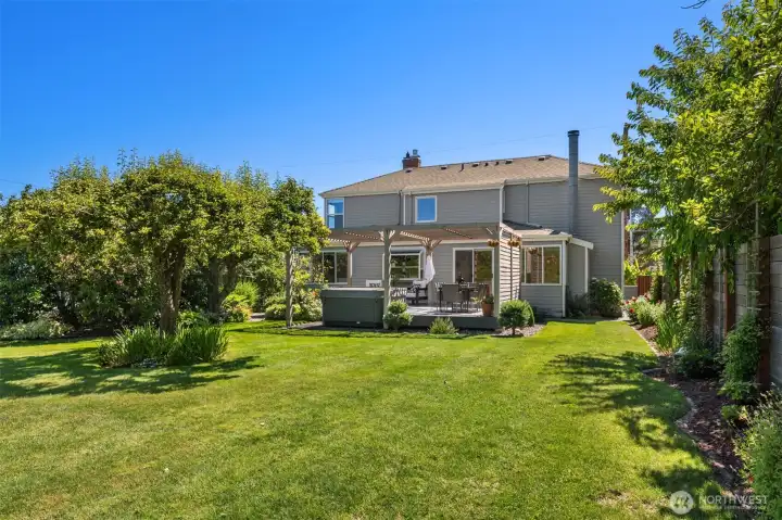 The gorgeous backyard is lush and beautiful with ample grass areas framed by manicured gardens.
