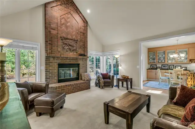 Open to the kitchen and informal dining area is this inspiring family room with vaulted ceilings and oversize windows.