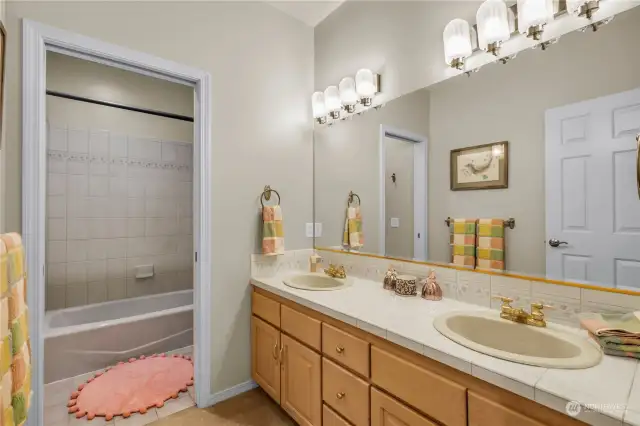 This bright bathroom serves both the bedrooms with a very large linen closet opposite the entry.