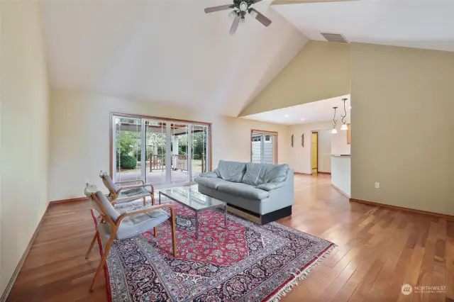 Living room with vaulted ceiling looking out to the covered patio