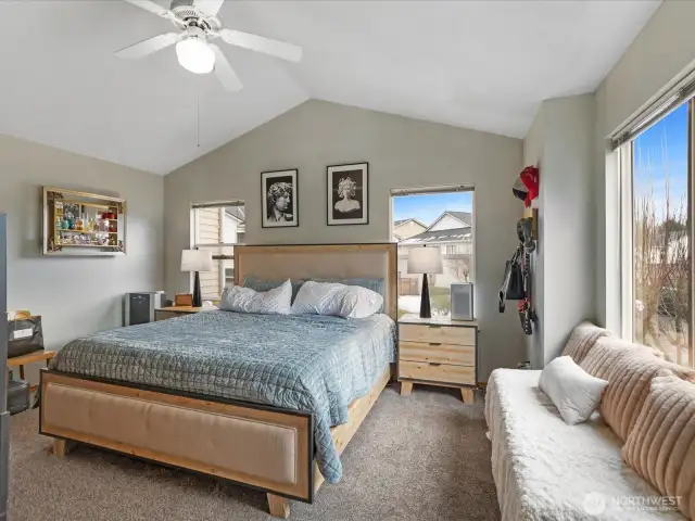 Oversized primary bedroom with vaulted ceiling & ceiling fan. Notice the large windows & amount of space in the gorgeous room!