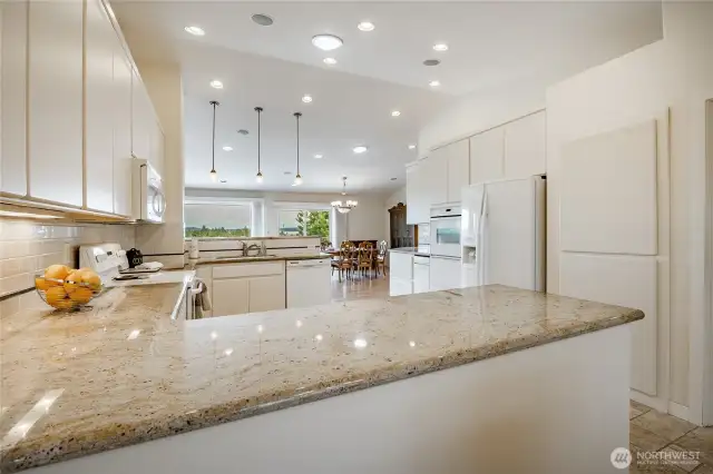 View across the kitchen with granite counter tops, tons of cabinets, great lighting and more.