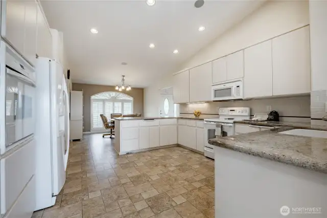 View from dining rooms side of the kitchen. See oven and wall oven. Trash compactor as well.