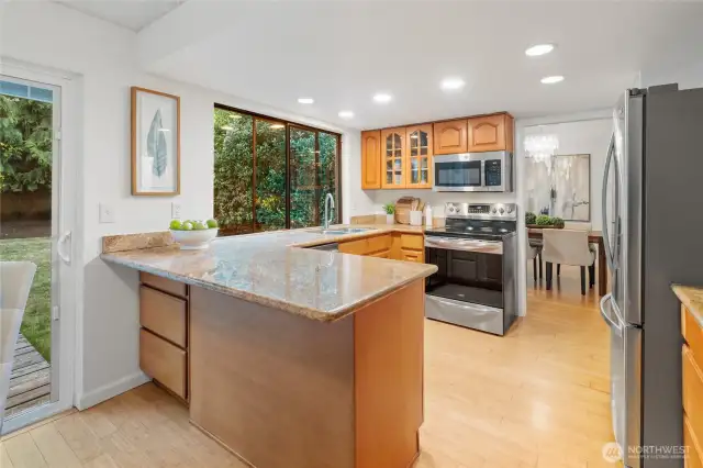 This open-concept kitchen with stone countertops, maple cabinets, and stainless steel appliances make this space both functional and stylish—with room for bar seating and did you notice the hidden cabinet tucked beneath the end of the counter? A clever touch that adds even more storage without sacrificing style.