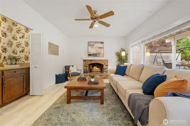 The family room features a classic brick fireplace, large windows, and a built-in wet bar—ideal for game nights, movie marathons, or easy entertaining.