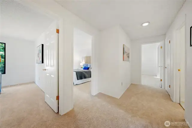 The upper-level hallway guides you to the additional bedrooms, a full guest bathroom, and the secluded Primary Suite tucked at the end—offering a functional layout that balances shared and private spaces beautifully.