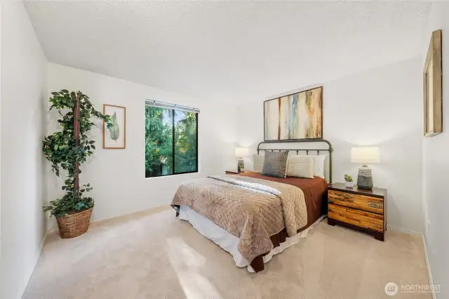 Bedroom One: Bright and serene, this upstairs bedroom offers peaceful views of the surrounding greenery—perfect as a guest room or creative studio.