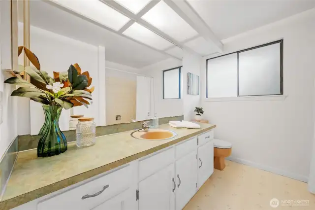 Conveniently located near the additional bedrooms, this full bathroom features ample counter space, plenty of storage, and natural light—ideal for daily use or accommodating guests with ease.