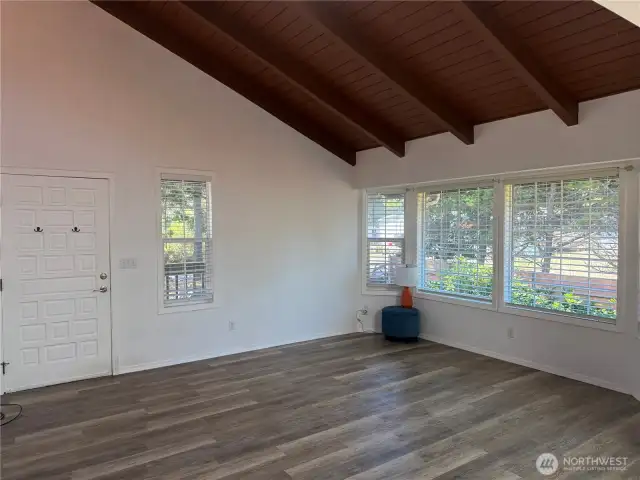Living room with cathedral wood ceilings. Large windows for lots of light.