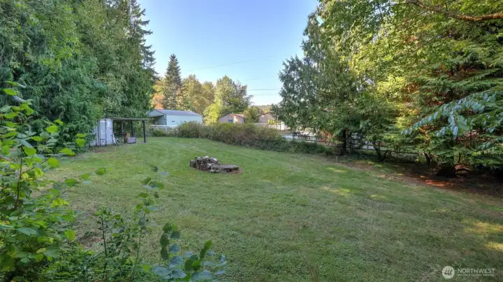 Expansive yard space framed by mature trees, perfect for recreation or relaxation.