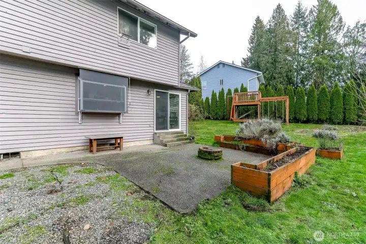 Outside find a fully fenced, partially tree lined backyard.