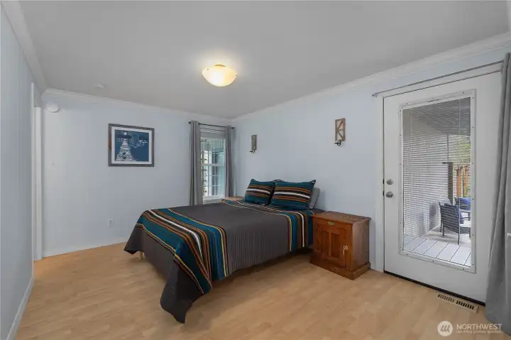 Spacious primary bedroom offers room to unwind with direct access to the private deck.