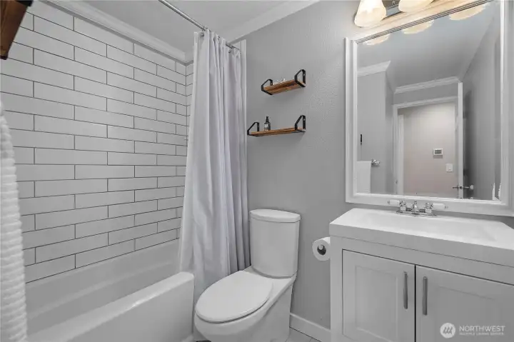 Updated full bath features clean finishes, subway tile surround, and modern fixtures.