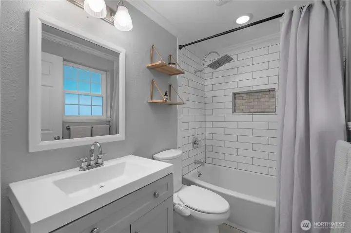 Stylish bathroom with crisp tilework and updated fixtures creates a bright, refreshed feel.