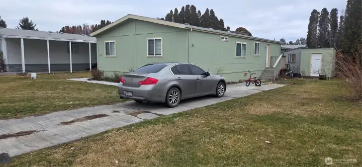 A view of the driveway, back porch, and shed.