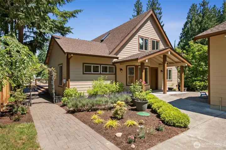 Welcome home to this thoughtfully updated custom A-Frame featuring inviting Craftsman-inspired architecture, a covered front porch, attractive landscaping, paver walkways, and a peaceful setting nestled among mature evergreens.