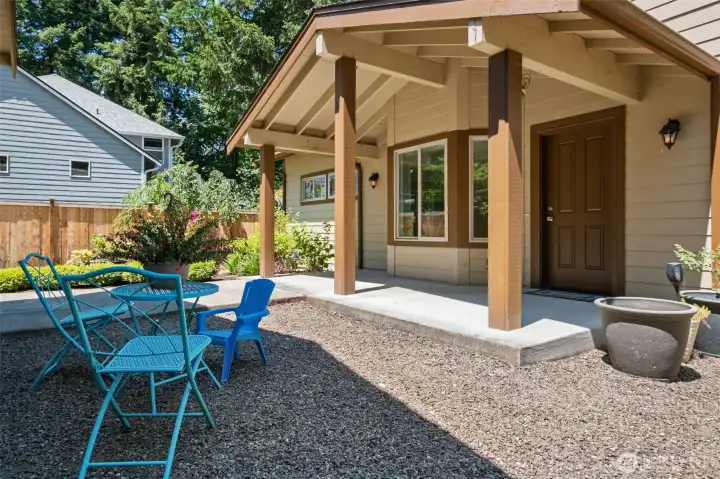 The inviting covered front porch creates the perfect spot to enjoy a morning cup of coffee or greet guests, complemented by exposed beams, sturdy Craftsman-style posts, and easy-care landscaping.