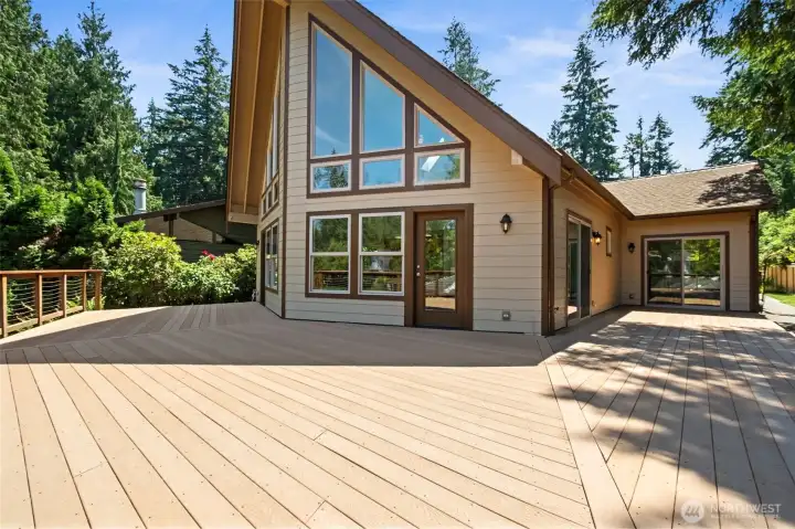 Extending the living space outdoors, the expansive entertainment deck is the perfect setting for al fresco dining, summer barbecues, and gathering with family and friends while taking in serene views of the creek and surrounding evergreens.