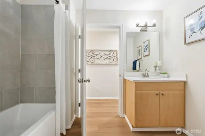 Updated main floor hall bathroom with tiled tub & shower surround, new flooring and fixtures.