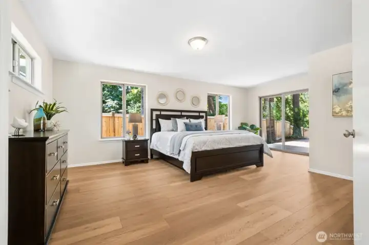 Enjoy the convenience of main-floor living in this expansive primary suite featuring wide-plank flooring, abundant natural light, and private sliding glass doors opening to the deck—perfect for morning coffee or unwinding at day's end. Plus with wide hallways & doors & accessible bathroom, this is perfect for wheelchair needs!