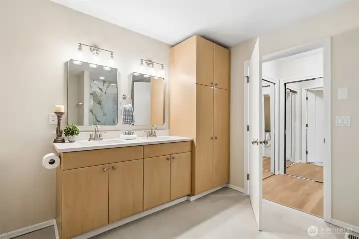 The spacious main floor primary ensuite was thoughtfully designed with aging in place in mind, featuring a wide double vanity, generous storage, easy maneuverability, and an adjoining barrier-free shower, creating a beautiful and functional retreat for everyday comfort.