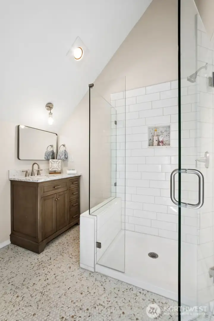 Thoughtfully remodeled from top to bottom, this stunning new ¾ bath showcases a spacious glass-enclosed shower, timeless white subway tile, designer finishes, and a furniture-style vanity with quartz countertop.