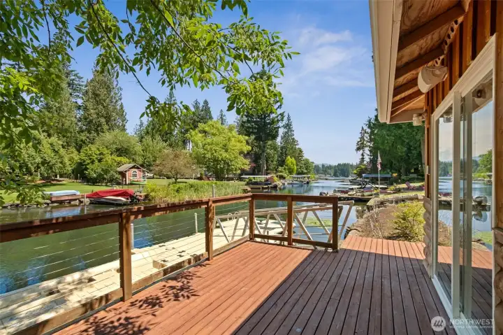The charming waterfront boathouse is the ultimate destination for lakeside living, featuring a spacious deck overlooking Covington Creek, private dock access, and the perfect setting for morning coffee, sunset cocktails, or watching boats drift by on their way to Lake Sawyer.