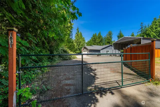 This home is secluded and private and features its own gated entrance. Seen here, next to the home, is an exceptionally wide and tall storage canopy for motorhomes or RVs and boats.