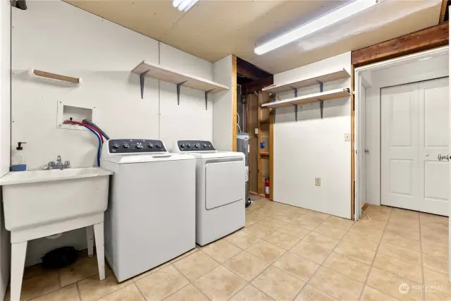 Utility room has tile floor. New appliances Washer / Dryer, Utility sink, Hot Water tank is easy access. Tons of storage shelves for supplies.
