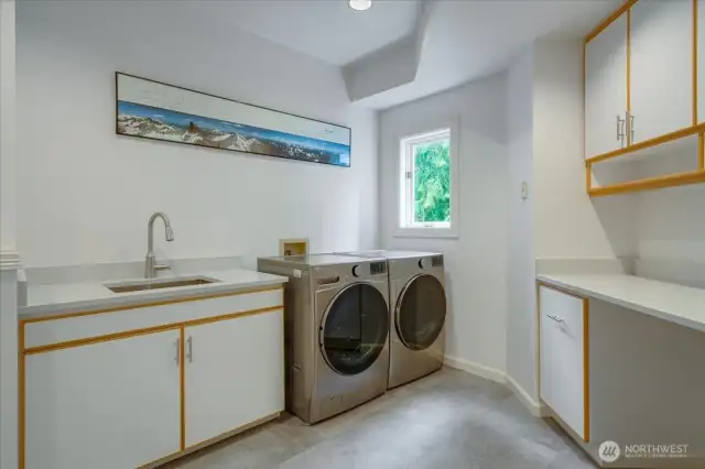 The spacious laundry room is off the back hallway with abundant cabinetry, newer washer and dryer.