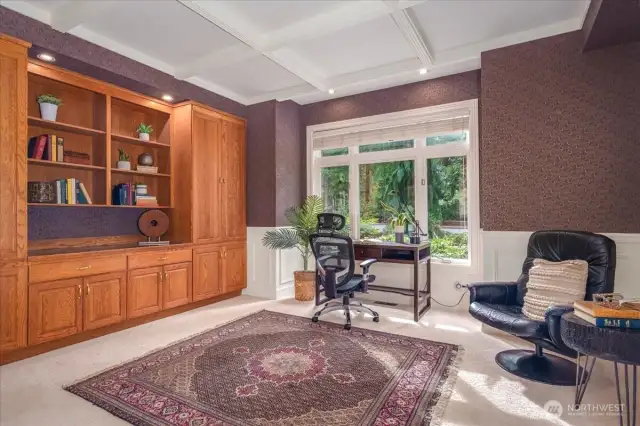 The office or study is off the foyer and features a wall of built-in cabinetry, wainscoting and tray ceiling.