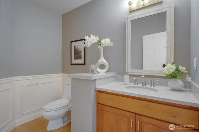 The guest powder room with quartz vanity is conveniently located off this hallway.