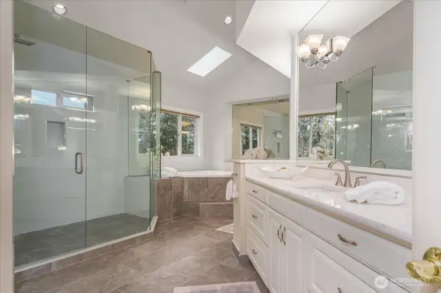 Updated 5 piece bathroom with designer tiled floor and shower, 2-person jetted tub, crisp white cabinetry with separate quartz vanities.