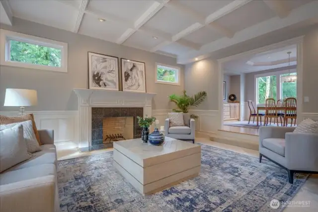 The formal rooms off to the left feature a marble surround wood burning fireplace, wainscoting and tall tray ceiling.
