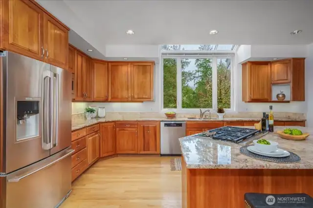 Stainless steel Wolf double ovens, 5 burner Wolf gas stove, large center island with bar seating.