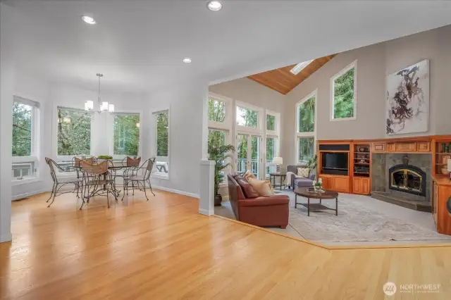 The adjacent informal dining area with walls of windows overlooks the east facing yard.